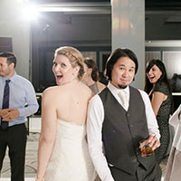 Bride and Groom smile on wedding dance floor holding drinks