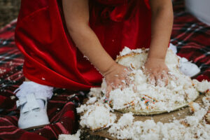 Little girl smashing a wedding cake